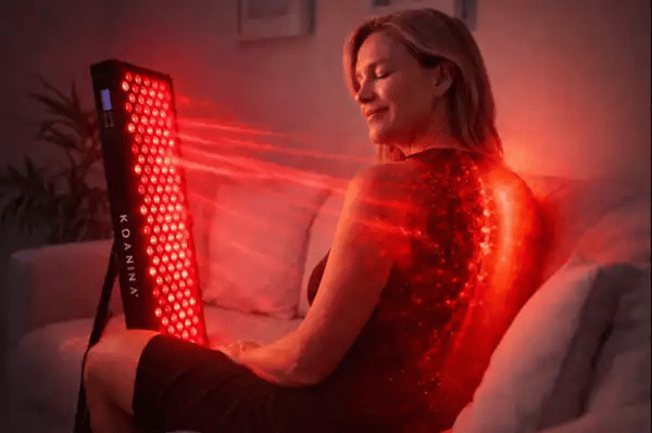 Woman uses Luma 1000 red light panel for pain relief